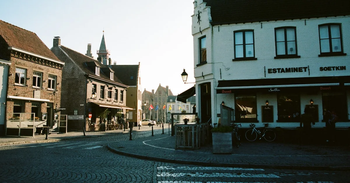 A quiet European village square in early morning light, empty cobblestones and ancient buildings