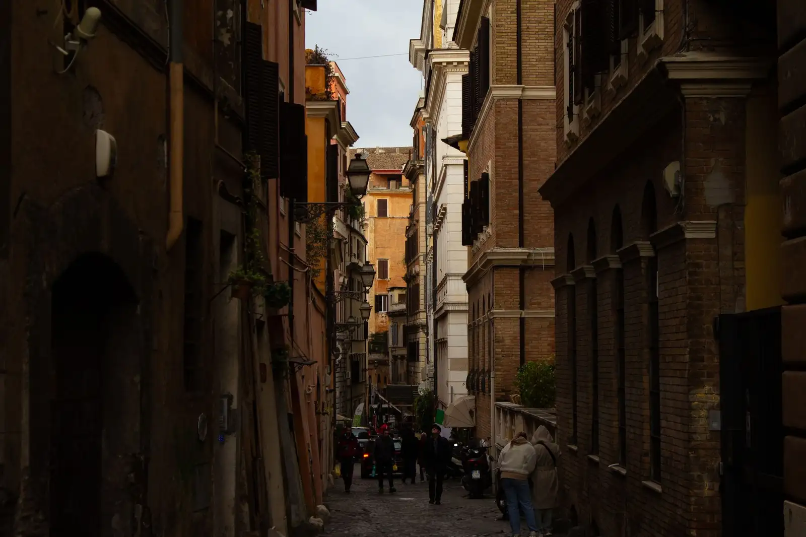A narrow cobbled street lined with historical buildings, capturing urban European charm.